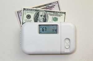 Thermostat with cash $100 bills behind it